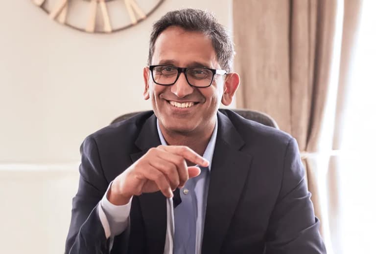 Professor Prasanna Sooriakumaran smiling in his clinic