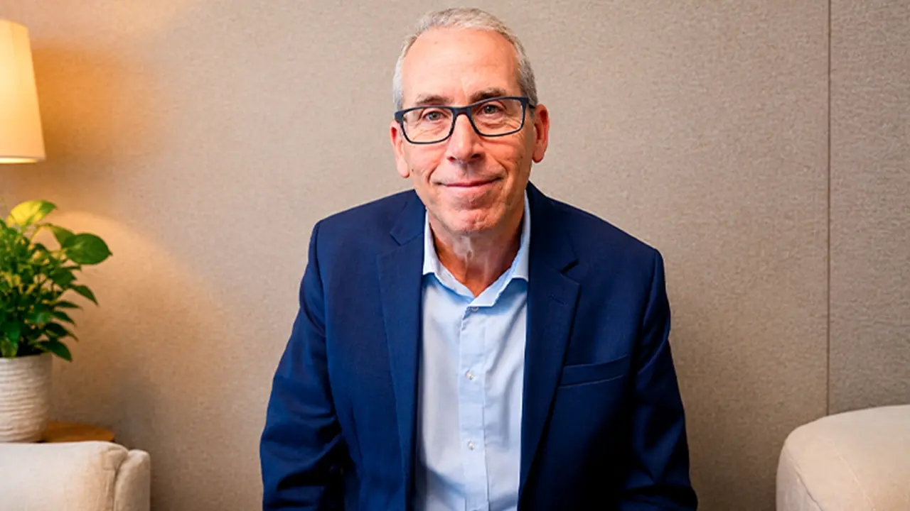 Smiling older man seated on a sofa, prostate cancer treatment video thumbnail