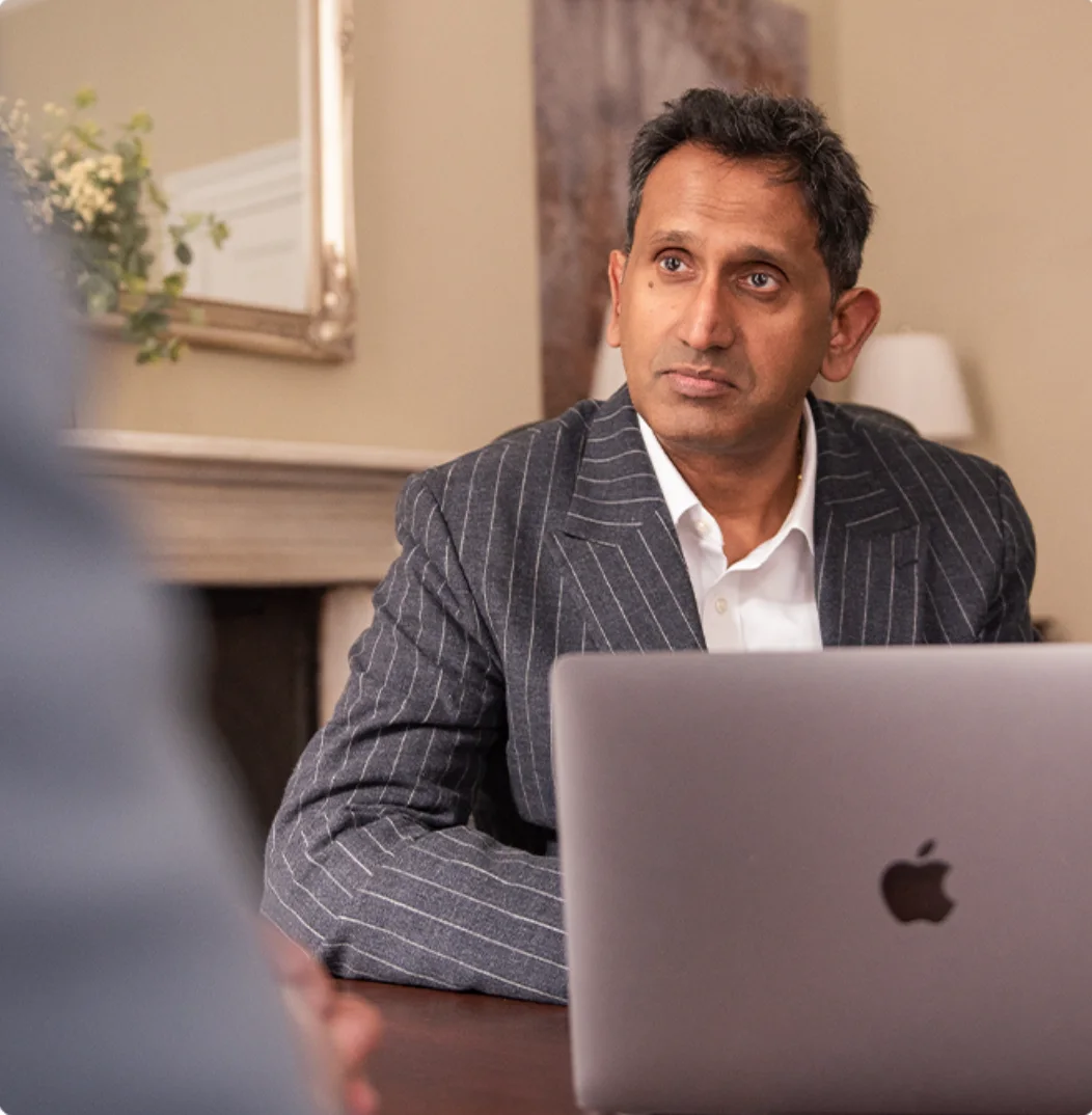 Professor Prasanna Sooriakumaran at his laptop, reviewing PSA results with a patient
