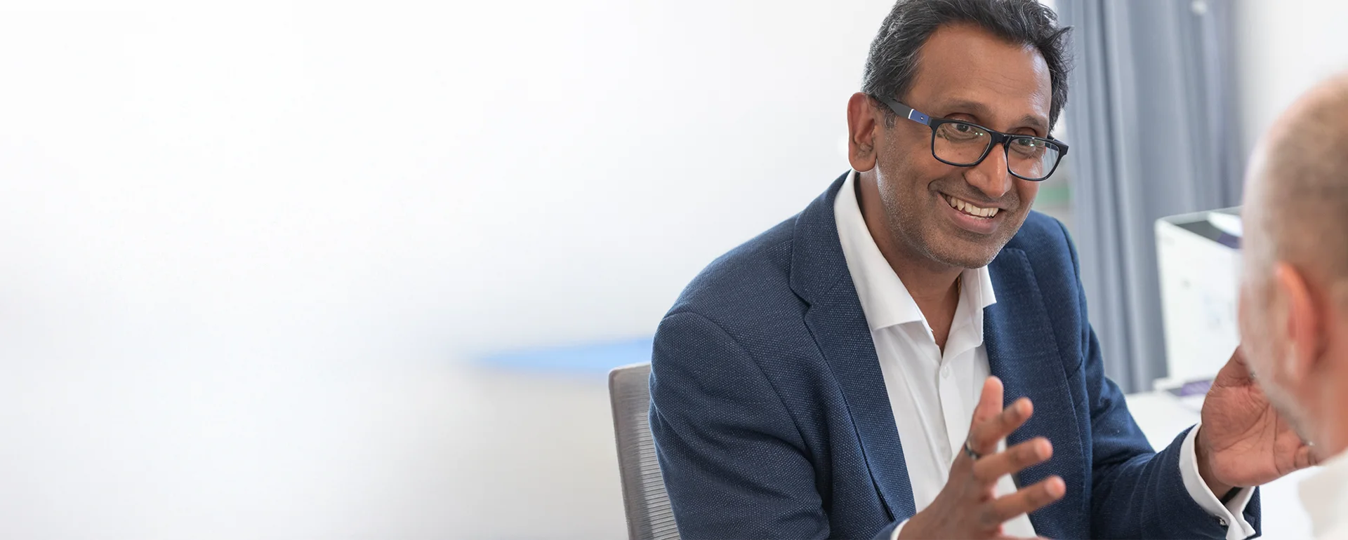 Professor Prasanna Sooriakumaran smiling during a patient consultation