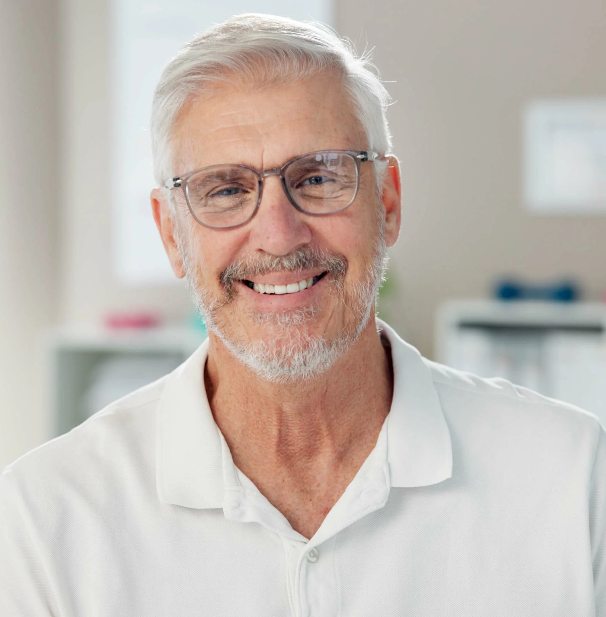 Smiling older man with glasses in a white polo shirt