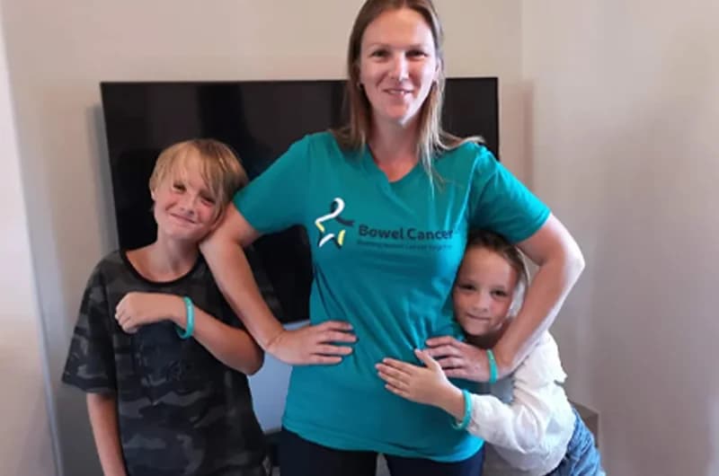 Smiling woman standing with her two children