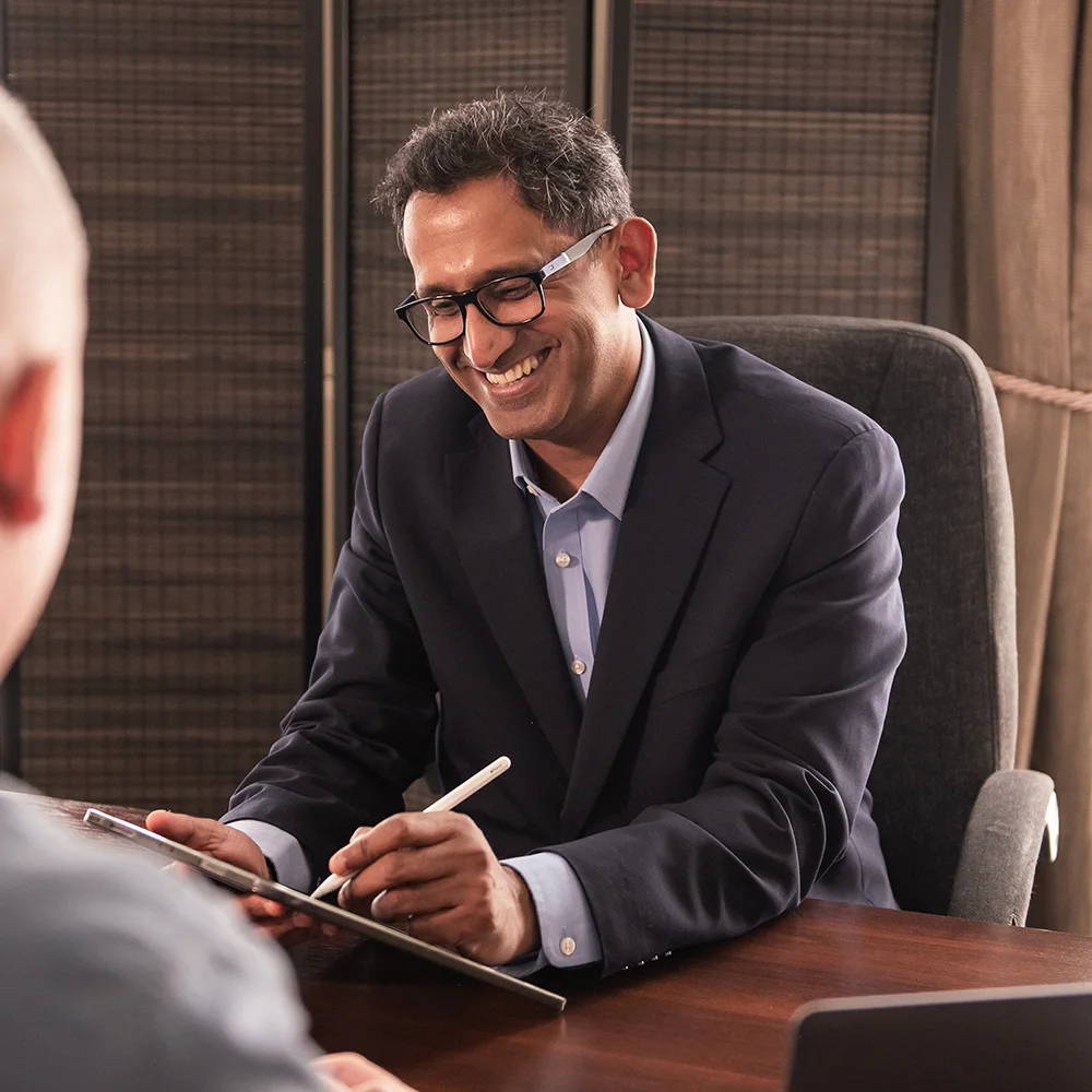 Professor Prasanna Sooriakumaran taking notes during a patient consultation