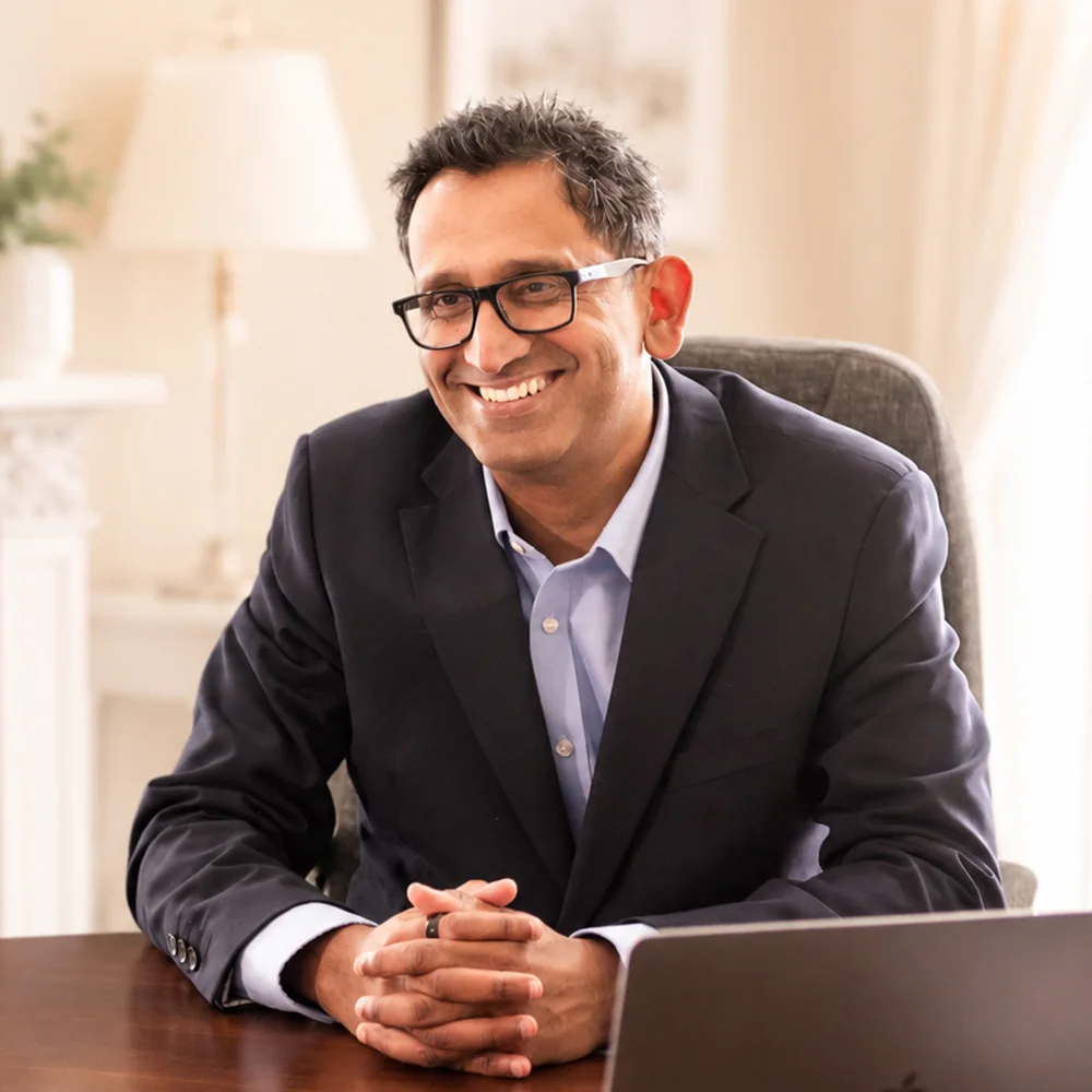 Professor Prasanna Sooriakumaran smiling at his desk, prostate cancer treatment video