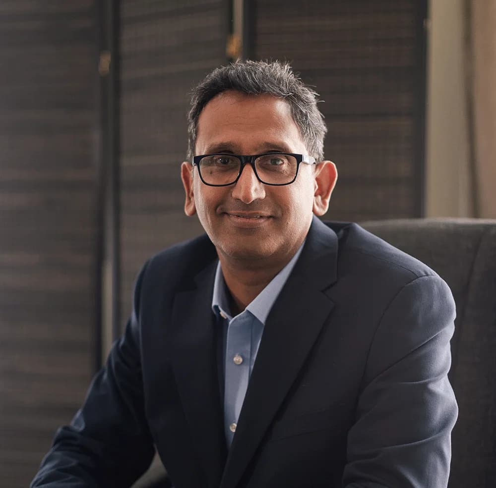 Professor Prasanna Sooriakumaran, Professor of Urology, seated in his clinic