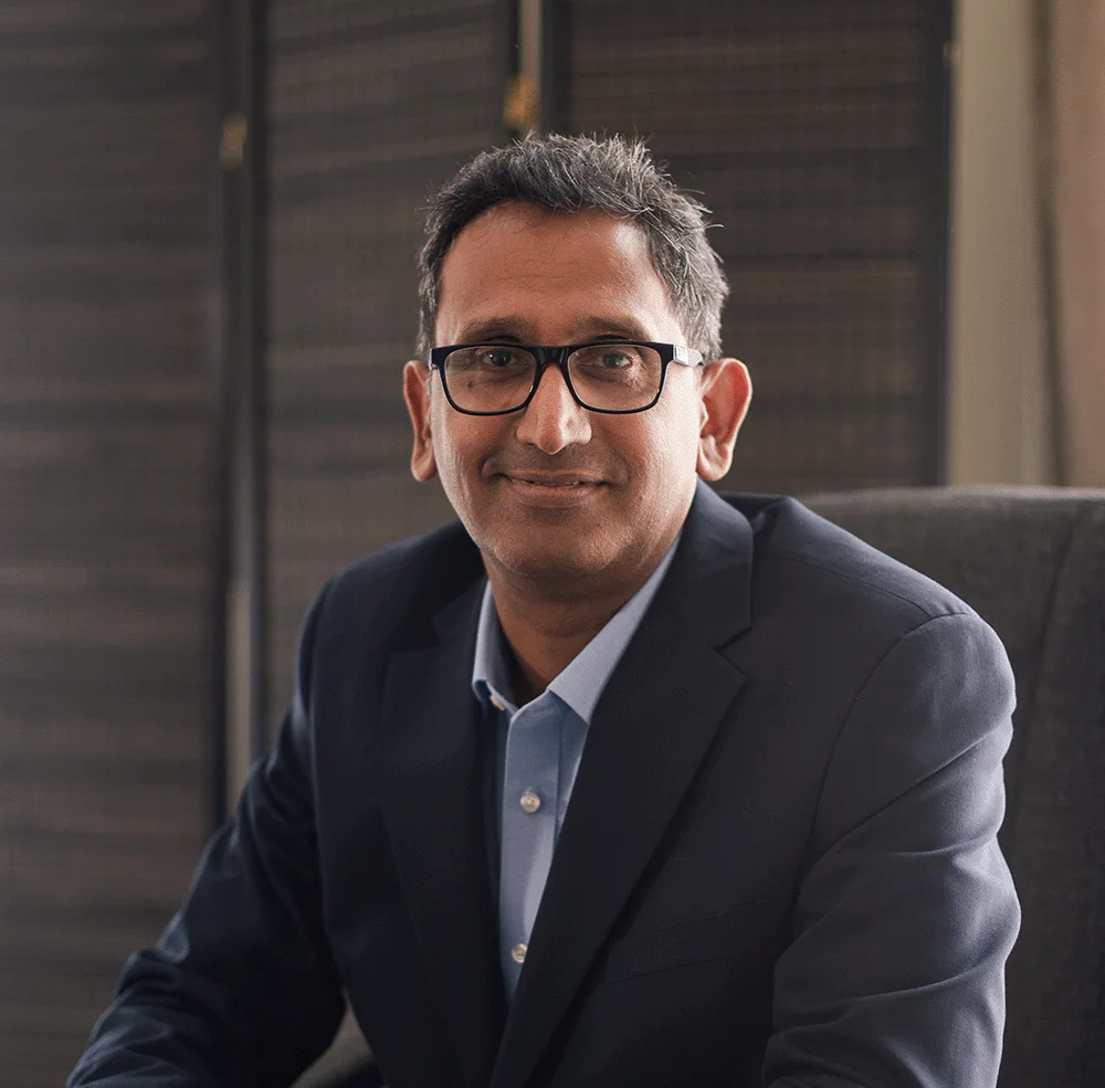 Professor Prasanna Sooriakumaran, Professor of Urology, seated in his clinic