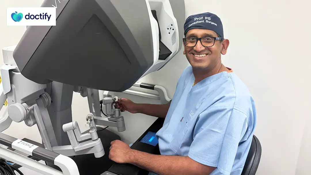 Professor Prasanna Sooriakumaran in scrubs at a robotic surgery console