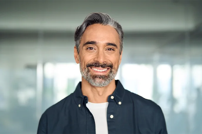 Smiling mature man with a grey beard in an office