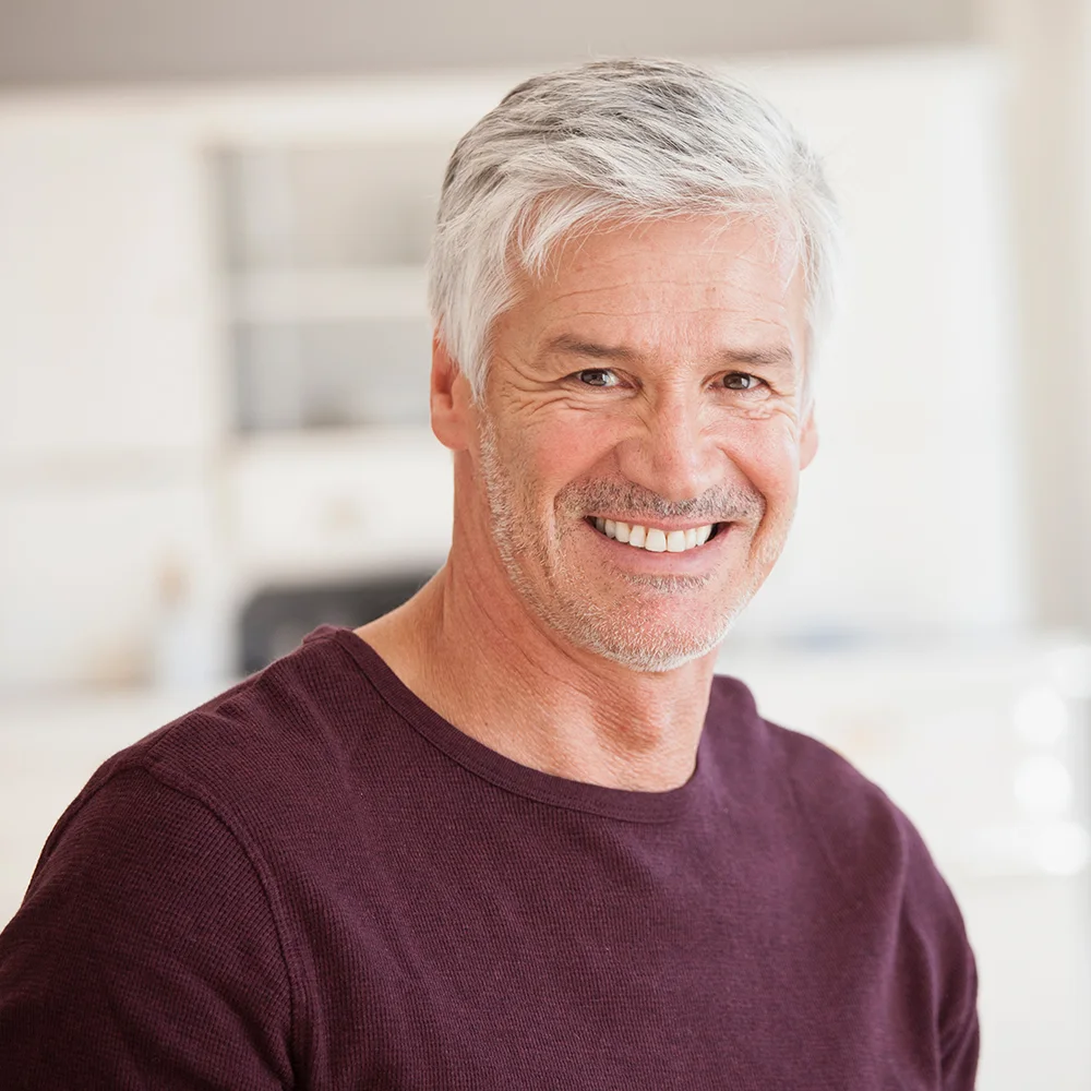 Smiling grey-haired man in a burgundy jumper