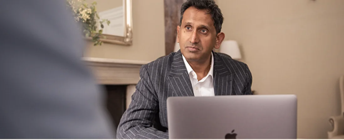 Professor Prasanna Sooriakumaran at his laptop in consultation
