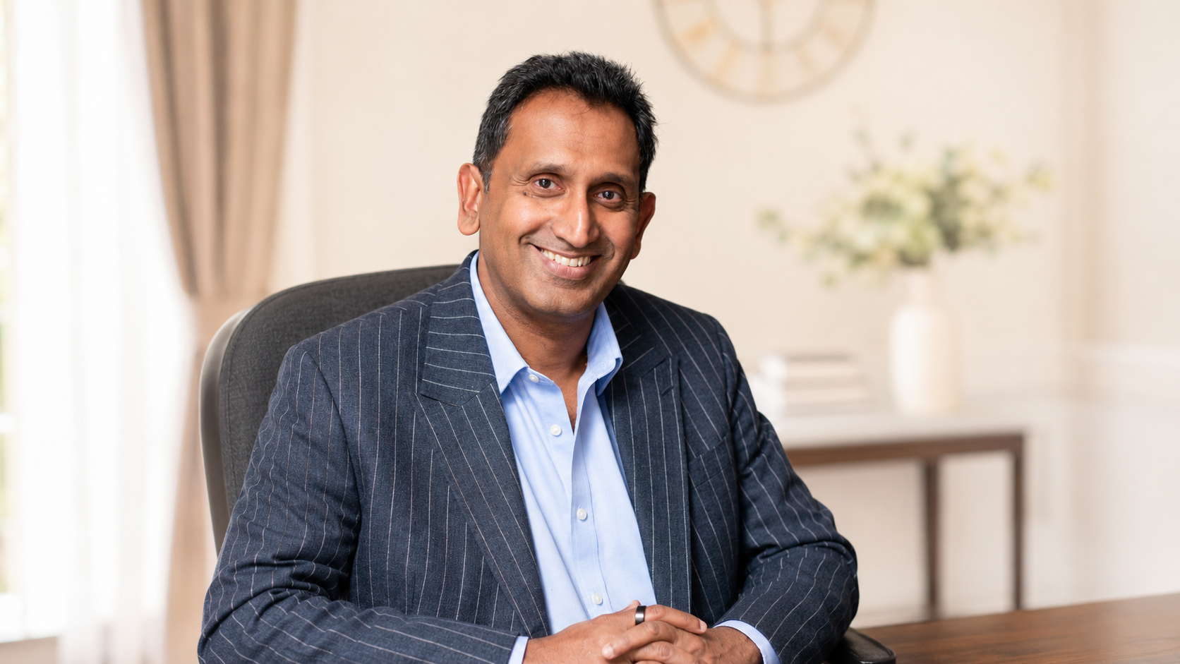 Professor Prasanna Sooriakumaran seated in his clinic